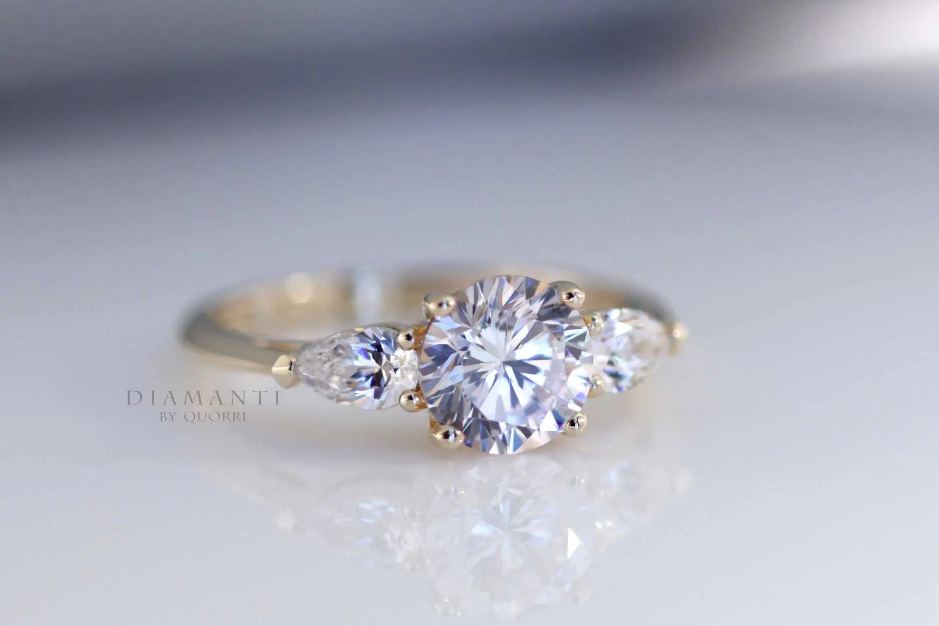 yellow gold three stone 2.5 carat round and pear accented lab diamond engagement ring